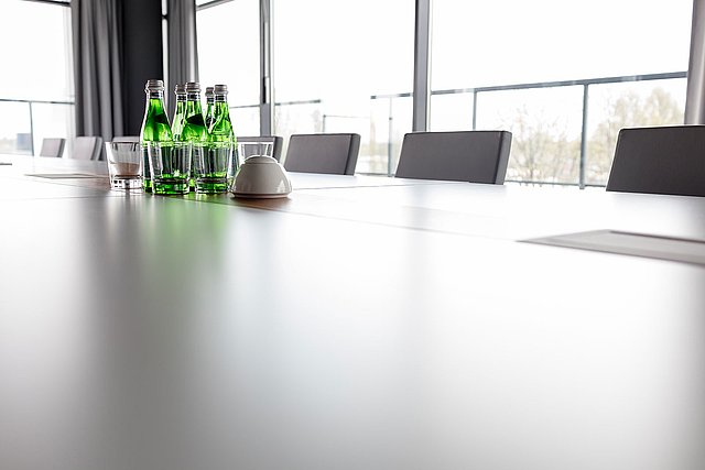 A close up of a conference table having a view out the window.